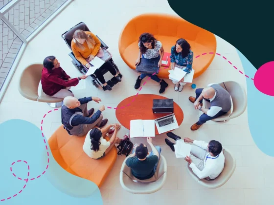 Top view of a large diverse group of people sitting at a round table in an office