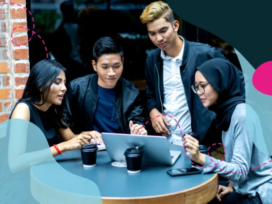 Four team members working on a computer together