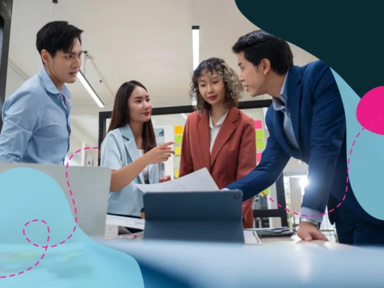 Four team members working on a computer together