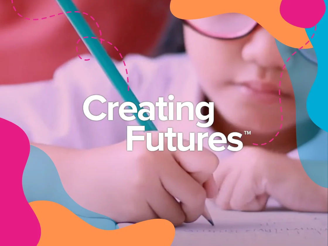 School girl writing in a book with the words "Creating Futures" overlaid