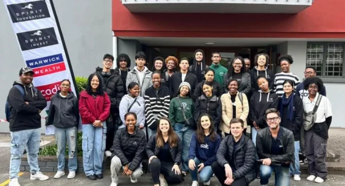 Group of students and facilitators posing together outside a building after a CV writing workshop.