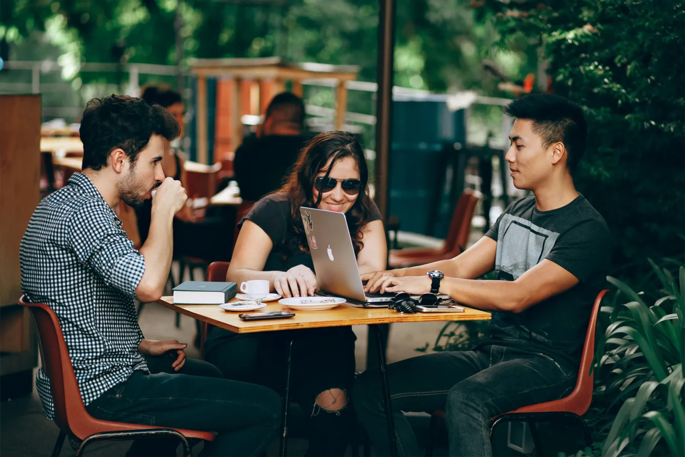 Three people working remotely at a restaurant