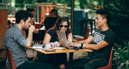 Three people working remotely at a restaurant