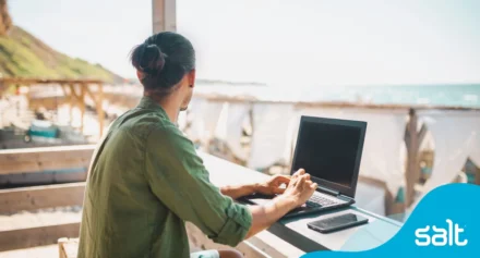 Man working remotely on his laptop at a cafe near the beach