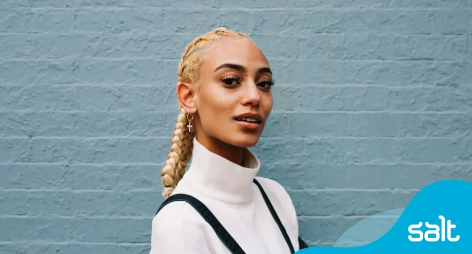 Person with braided hair against wall
