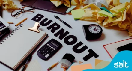 Close up of a messy desk with the word "burnout"