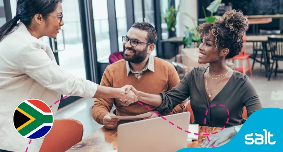 Diverse professionals in a modern office shaking hands, symbolising career opportunities and collaboration