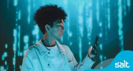 Person holding phone against digital backdrop