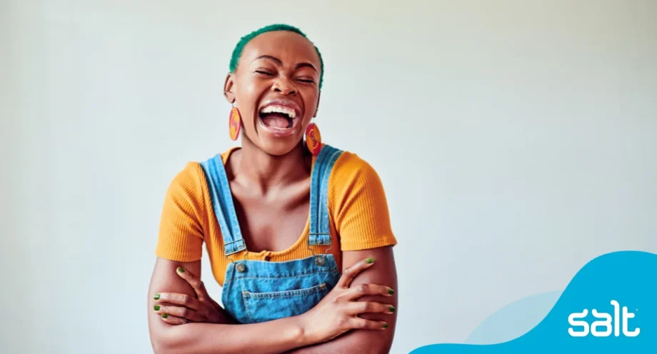 Woman proudly smiling wearing yellow shirt and dungarees
