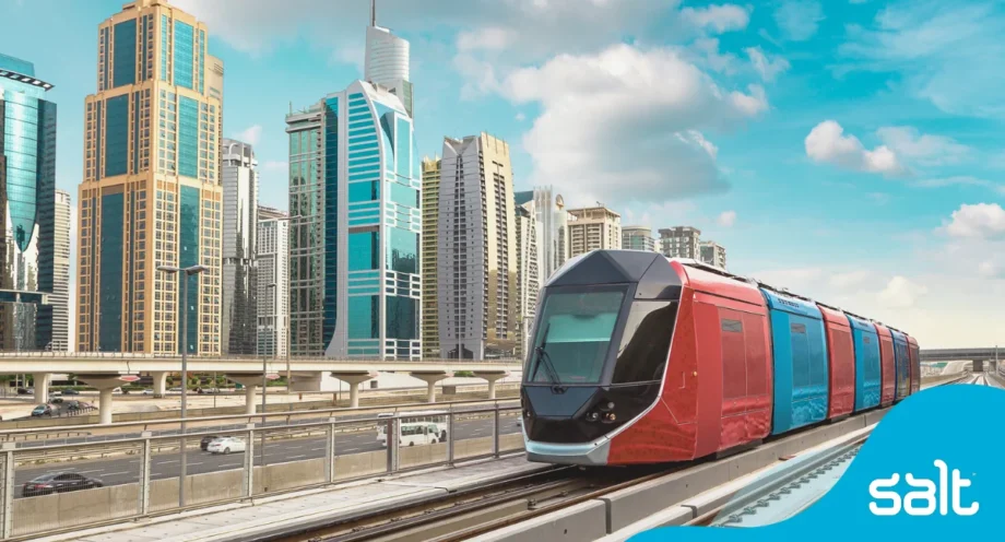 Tram on railway with Dubai city buildings in the background