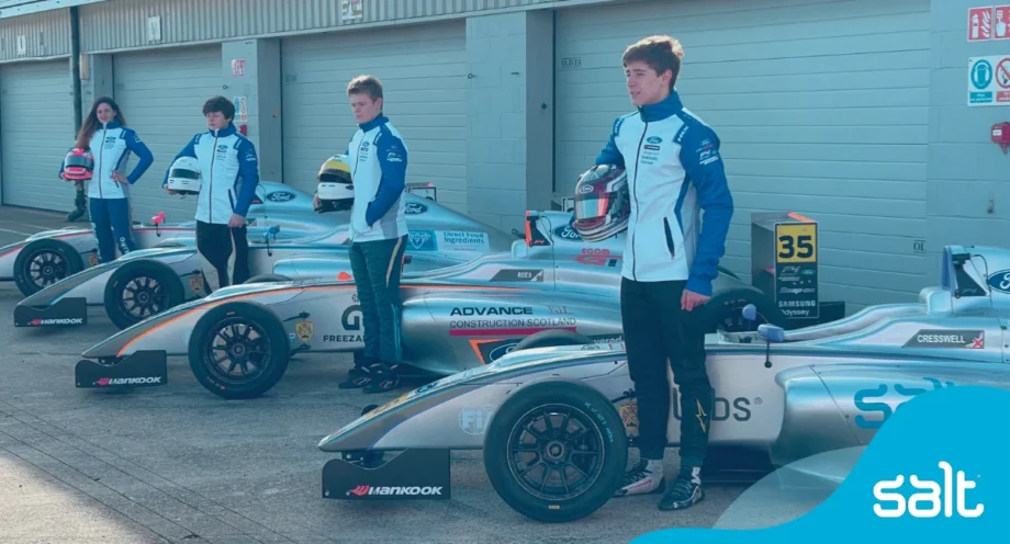 McKenzy Cresswell and team standing beside F1 race cars