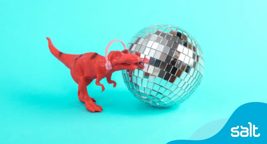 Playful red toy dinosaur with headphones and a disco ball, symbolising creativity, inclusion and attracting autistic talent