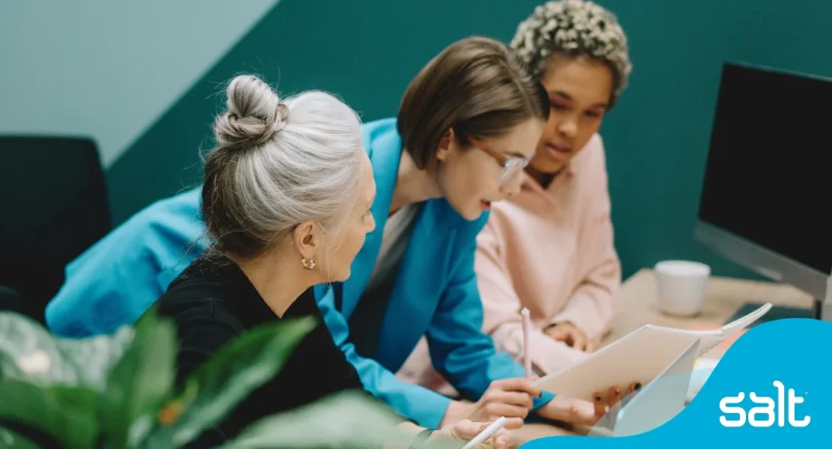 Three female colleague’s looking at something on a paper together