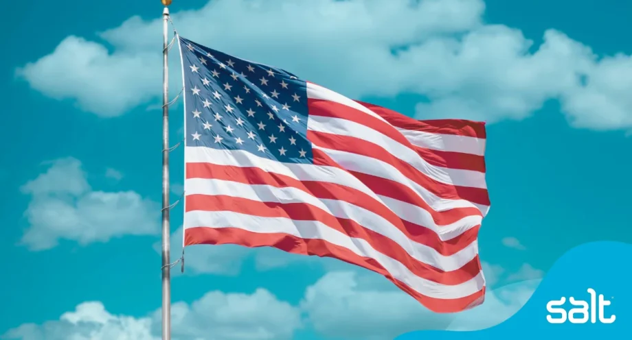 United States flag waving against a clear blue sky