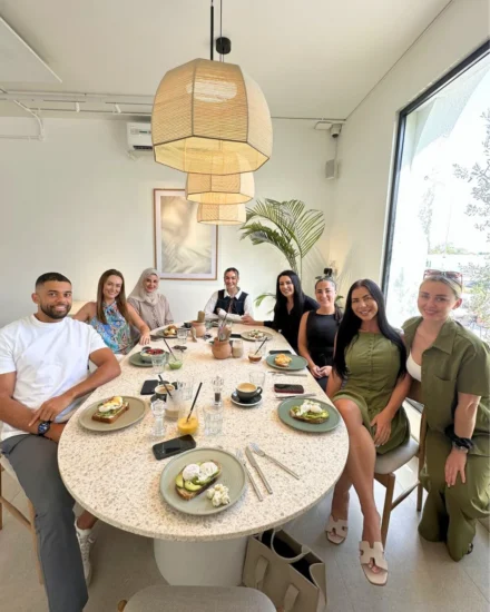 Salt team members enjoying a team lunch around a large table in a bright, modern café
