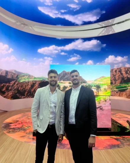Two men in suits standing at the LEAP 2024 tech event in Saudi Arabia, with a large scenic digital display and sky-themed ceiling behind them