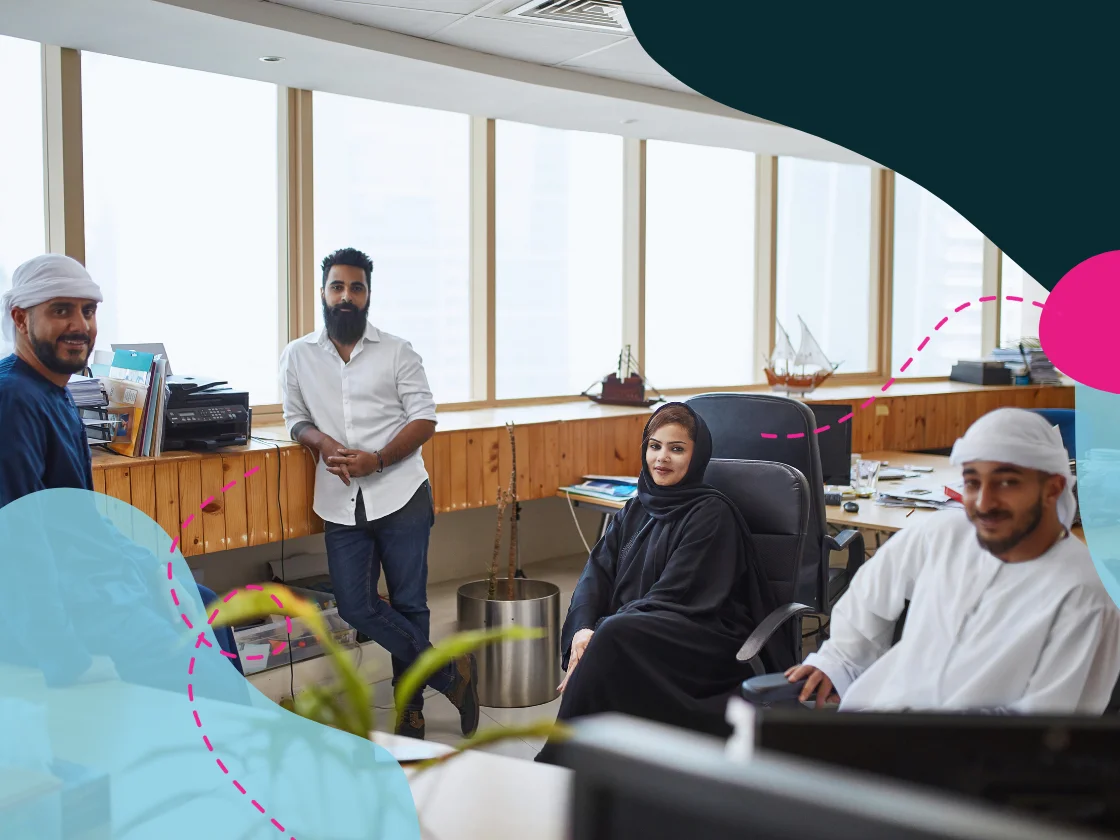 Emirati coworkers in an office smiling